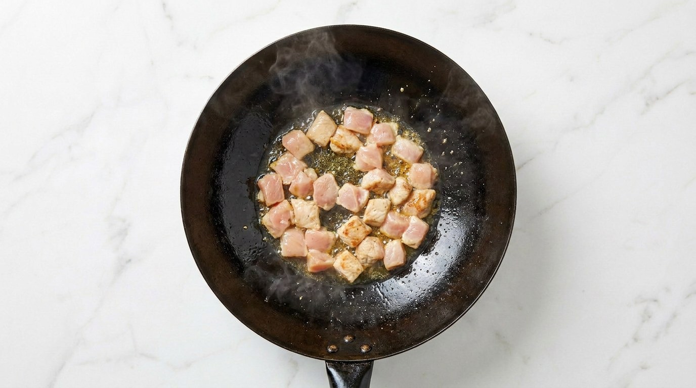 Stap 1: Snijd de kipfilet in blokjes en bak ze gaar in een hete wok.